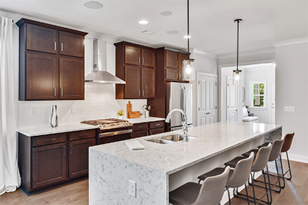 Large waterfall island with brown cabinets